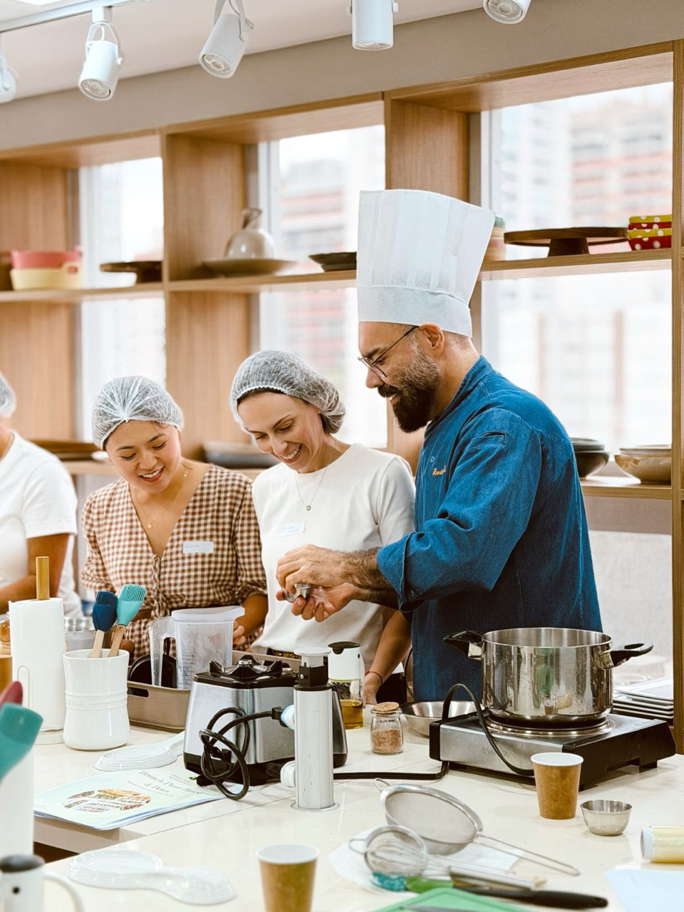 Chef conduzindo a aula com o grupo em volta da bancada